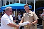 Bob Sheard is being presented a certificate for riding the LCAC by Senior Chief Darin Campbell
