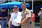 Jim Kress is being presented a certificate for riding the LCAC by Senior Chief Darin Campbell
